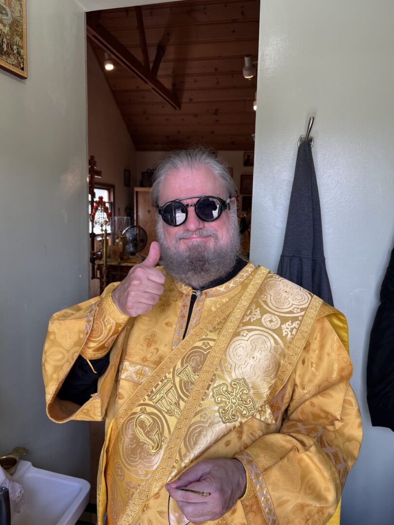 A man in gold and black outfit with sunglasses.